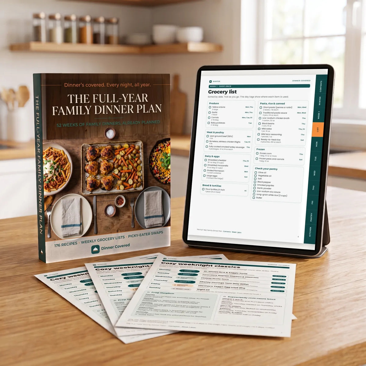 The Full-Year Family Dinner Plan on a tablet with printed pages